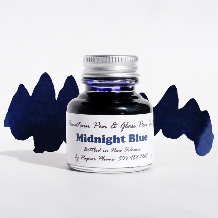 Bottle of Papier Plume Midnight Blue fountain pen ink with a clear glass container and dark blue ink visible inside.