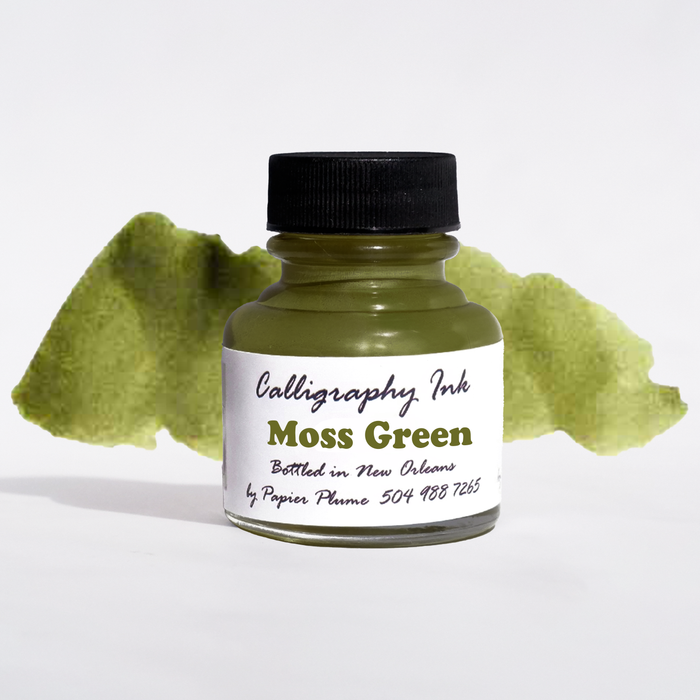 Moss green bottled calligraphy ink by Papier Plume, showing a glass bottle of rich green ink with calligraphy tools nearby.