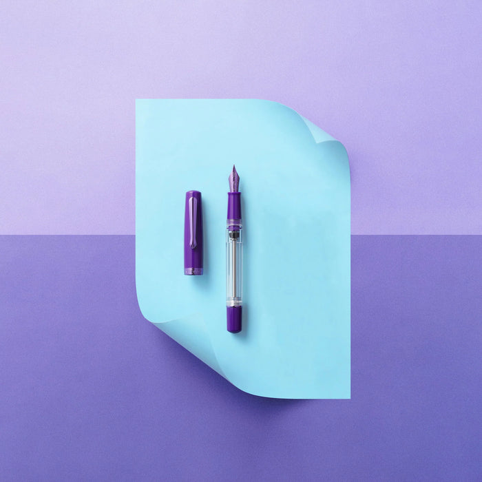 Nahvalur Original PLUS fountain pen with an amethyst-colored barrel and gold accents, showcasing a sleek, elegant design.