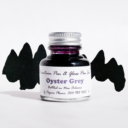 Papier Plume fountain pen ink bottle in Oyster Grey, showcasing the ink's smooth flow and elegant packaging.