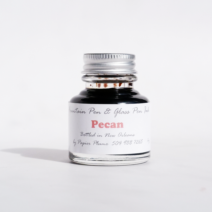 Papier Plume fountain pen ink in Pecan color, featuring a glass ink bottle with a black cap and gold label for writing and calligraphy.
