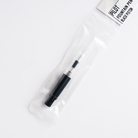 Black Pilot piston converter for fountain pens, showcasing a sleek design and high-quality construction.