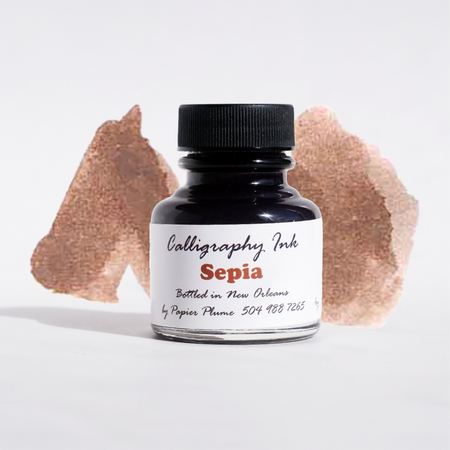 Bottle of Papier Plume sepia calligraphy ink with a clear label and black cap, perfect for artistic calligraphy projects.