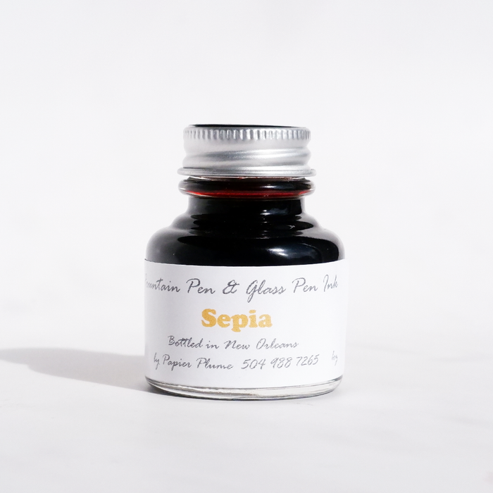 Sepia fountain pen ink by Papier Plume in a glass bottle, showing rich sepia ink for writing and calligraphy.