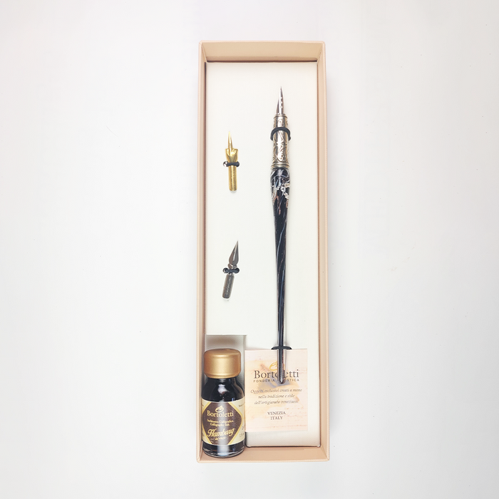 Set of 20 black Bortoletti glass dipping pens arranged on a white background for calligraphy and artistic writing.