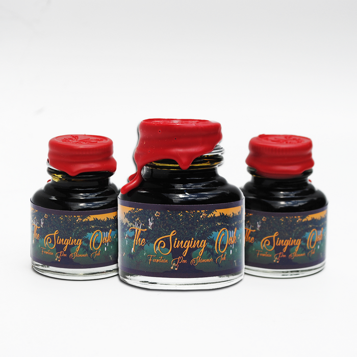 Papier Plume Singing Oak shimmer fountain pen ink bottle with dark ink and shimmering accents, ideal for writing and calligraphy.