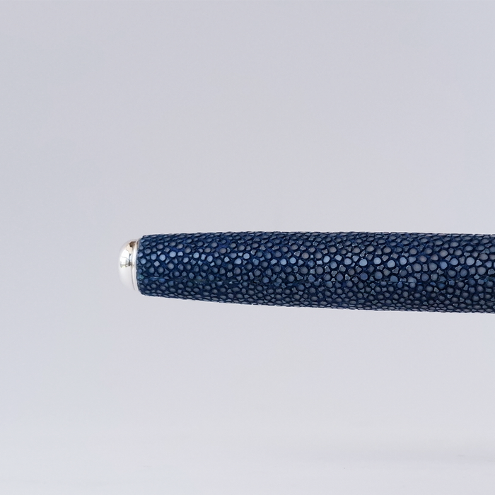 Blue Grifos Papier Plume Raya fountain pen with stingray leather grip, sleek design, and smooth metal nib.