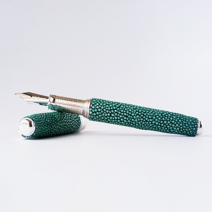 Green Raya plastic fountain pen with a sleek design from Grifos X Papier Plume, featuring a smooth writing tip and textured grip.
