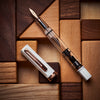 Twsbi Eco fountain pen in white with rose gold accents, featuring a smooth barrel and elegant nib.