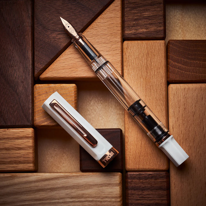 Twsbi Eco fountain pen in white with rose gold accents, featuring a smooth barrel and elegant nib.