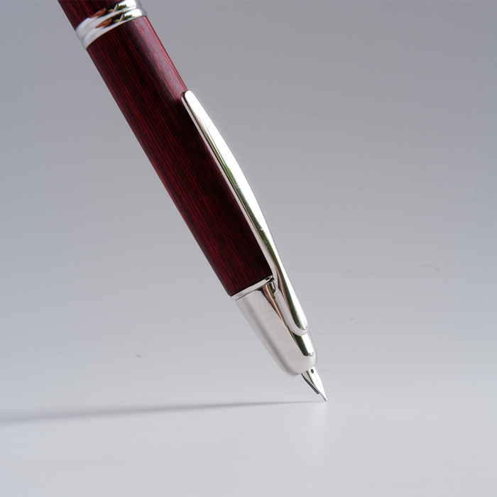 Pilot Vanishing Point fountain pen with a sleek birchwood barrel and gold accents, showcasing its elegant design.