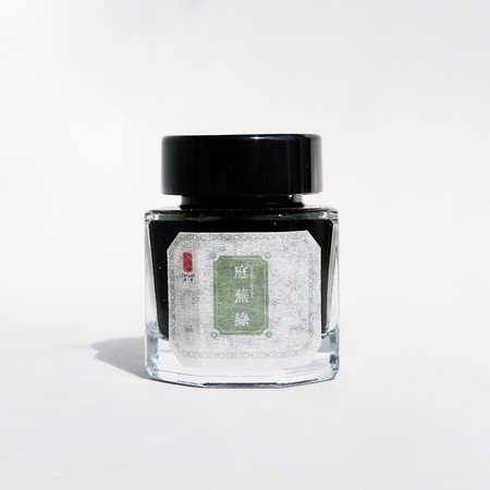 Cathay Verdant Courtyard fountain pen ink bottle with vibrant green ink, detailed label and ink cap in natural lighting.