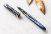 Visconti Comedia Caronte fountain pen with black resin body and gold accents, showcasing elegant craftsmanship and detailed design.