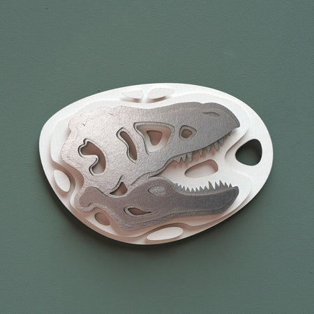 Silver Paper Fossil Art of a Tyrannosaurus craft by Assembli, showcasing detailed T-Rex design on metallic paper.