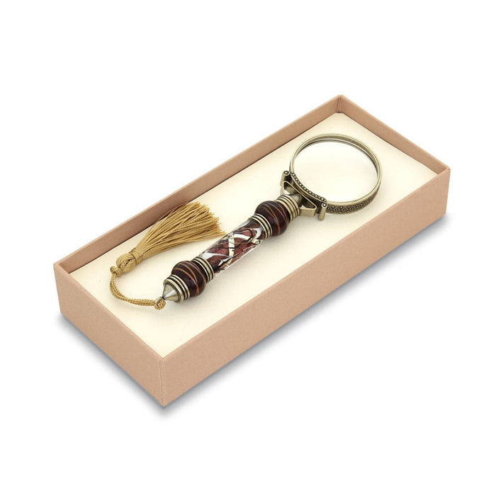 Bortoletti Murano glass magnifying glass with amber handle, silver leaf accents, and decorative tassel showing close-up details.
