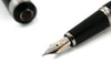 Cleo Skribent Aura fountain pen with black exterior and fine nib, showcasing elegant design and gold accents.