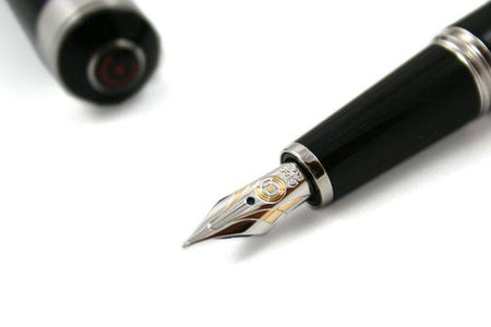 Cleo Skribent Aura fountain pen with black exterior and fine nib, showcasing elegant design and gold accents.
