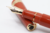 Conway Stewart Orange Duofold fountain pen with gold trim and fine nib, classic design, and vibrant orange resin body.