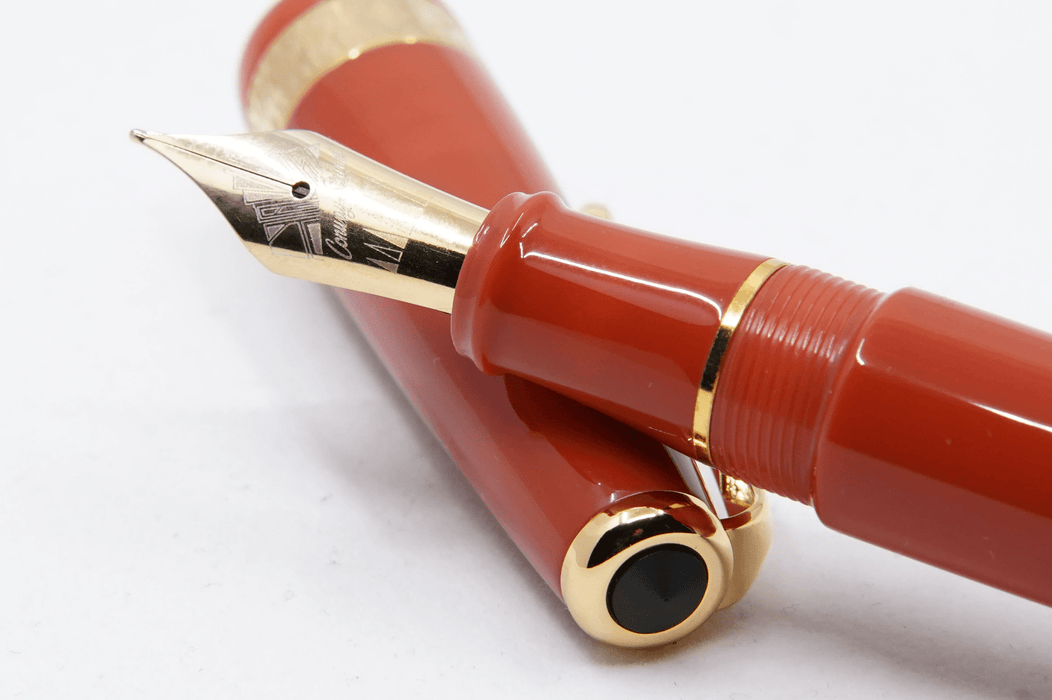 Conway Stewart Orange Duofold fountain pen with gold trim and fine nib, classic design, and vibrant orange resin body.