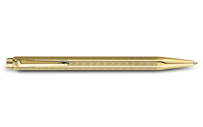 Caran D'Ache Gilded Ecridor Chevron ballpoint pen with gold accents, featuring a sleek chevron design and polished metal finish.