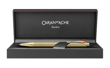 Caran D'Ache Gilded Ecridor Chevron ballpoint pen with gold accents and detailed chevron pattern, close-up view