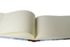 Large handcrafted guest book by Il Cartiglio with a marbleized cover and leather trim, featuring blank pages for guest signatures.