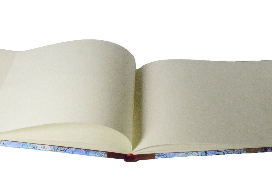 Large handcrafted guest book by Il Cartiglio with a marbleized cover and leather trim, featuring blank pages for guest signatures.