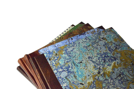 Large handcrafted guest book by Il Cartiglio with a marbleized cover and leather trim, perfect for special occasions.