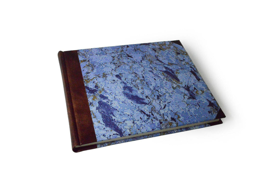 Small handcrafted guest book by Il Cartiglio with a marbleized green cover and leather trim, perfect for special events.