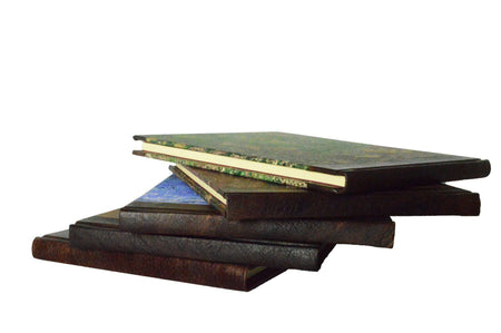 Small handcrafted guest book by Il Cartiglio with dark green marbleized cover and leather trim, ideal for guest signatures.