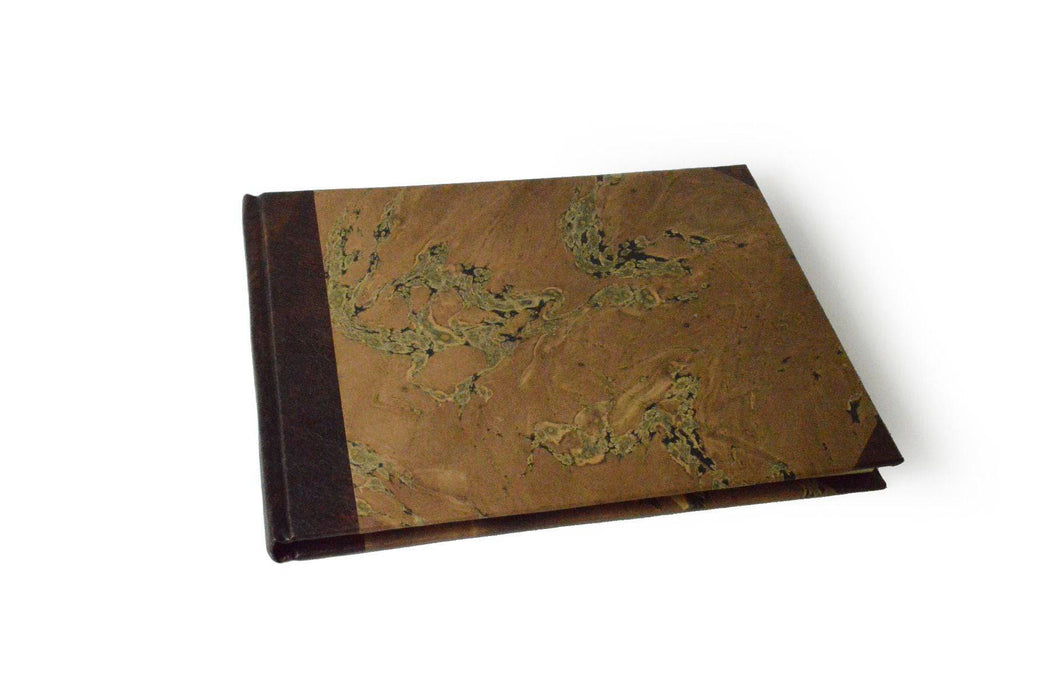 Small handcrafted guest book by Il Cartiglio with dark green marbleized cover and leather trim, ideal for special occasions.