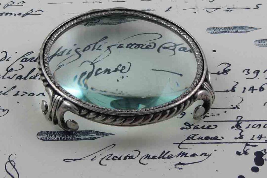 Large Le Potier D'etain magnifying glass on feet, circular design, with a clear glass lens for detailed viewing.