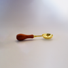 Large gold Papier Plume wax melting spoon for applying and handling wax in beauty or candle-making applications.