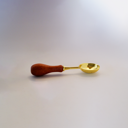 Large gold Papier Plume wax melting spoon for applying and handling wax in beauty or candle-making applications.