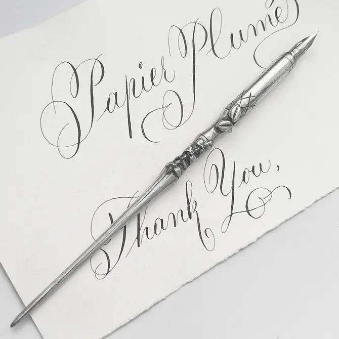 Le Potier D'etain pewter calligraphy dip pen with fleur-de-lys design, featuring a sleek and elegant pen tip for artistic writing.