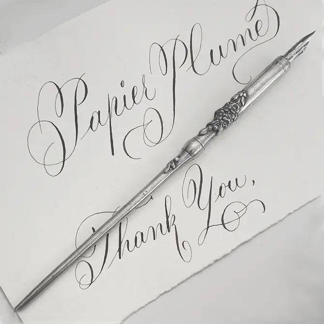 Le Potier D'etain pewter calligraphy dip pen with a fleur-de-lys design, ideal for elegant handwriting and artistic writing.