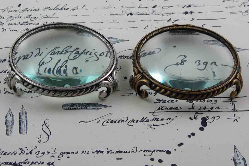 Large pewter magnifying glass on feet with circular frame by Le Potier D'etain, close-up of the detailed design.