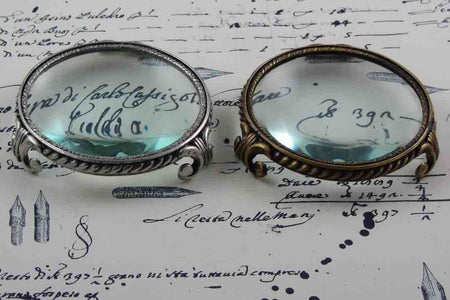 Large pewter magnifying glass on feet with circular frame by Le Potier D'etain, close-up of the detailed design.