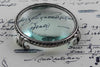 Large pewter magnifying glass on feet, circular design by Le Potier D'etain, detailed close-up of the vintage-style magnifier.