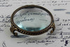 Large pewter magnifying glass on feet with round shape by Le Potier D'etain, detailed close-up of the vintage-style magnifier.