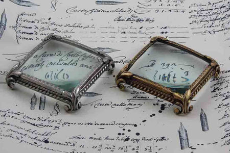 Large pewter magnifying glass on square feet by Le Potier D'etain, detailed close-up of the vintage-style glass and ornate base.