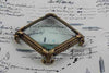 Large pewter magnifying glass on feet, square shape, by Le Potier D'etain, detailed close-up with ornate design.