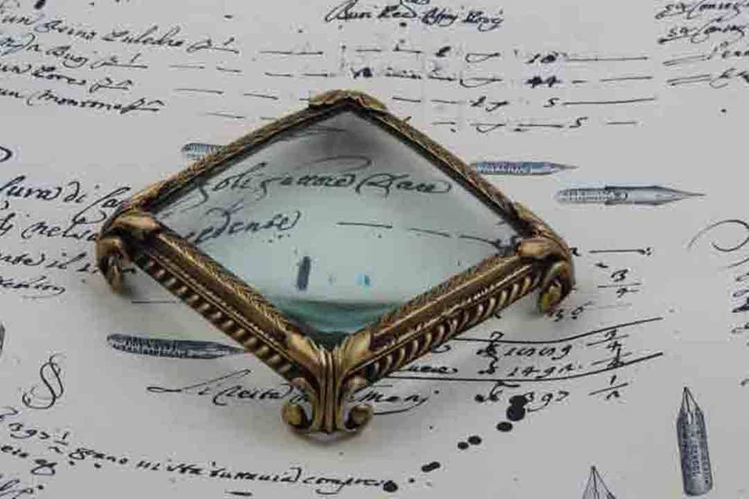 Large pewter magnifying glass on feet, square shape, by Le Potier D'etain, detailed close-up with ornate design.