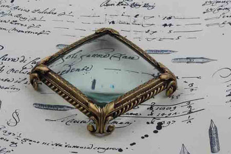 Large pewter magnifying glass on feet, square shape, by Le Potier D'etain, detailed close-up with ornate design.