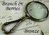 Large Le Potier D'etain magnifying glass with handle featuring a branch and berries design in pewter.