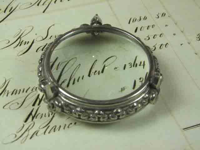 Small pewter magnifying glass on feet with fleur de lys design by Le Potier D'etain, detailed antique-style magnifier.