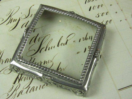 Small pewter magnifying glass on feet, square-shaped by Le Potier D'etain, with detailed craftsmanship and vintage design.