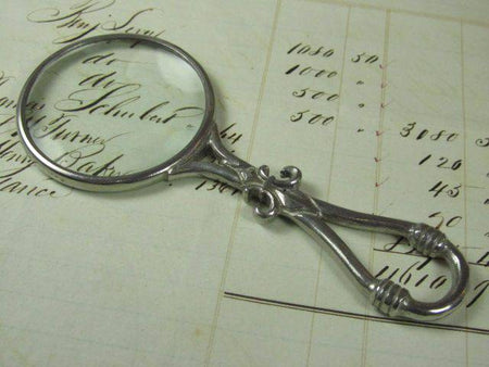 Small pewter magnifying glass with handle featuring a fleur de lys design, by Le Potier D'etain.