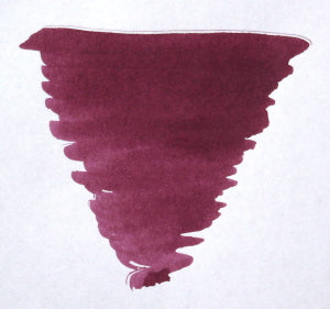 Bottle of Diamine Merlot fountain pen ink showing deep red ink inside a clear glass bottle.
