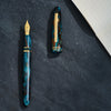 Esterbrook x BUNGUBOX Kingfisher Limited Edition Estie fountain pen with a vibrant blue and gold design on a white background.
